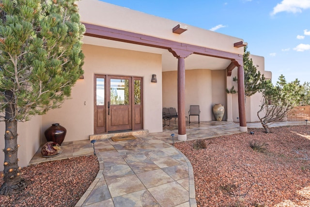 entrance to property with a patio and stucco siding