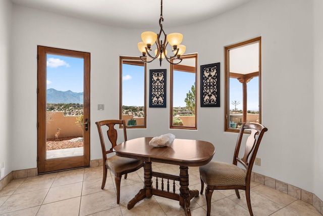 dining space featuring a mountain view, baseboards, and a notable chandelier