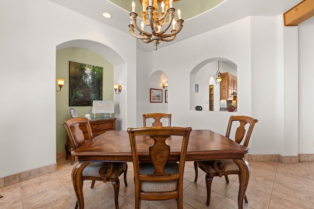 dining room with arched walkways, baseboards, a notable chandelier, and recessed lighting