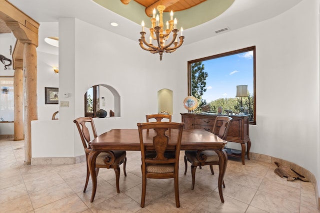 dining room featuring a towering ceiling, baseboards, visible vents, an inviting chandelier, and light tile patterned floors