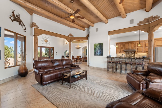 living area featuring visible vents, wooden ceiling, light tile patterned floors, arched walkways, and ceiling fan