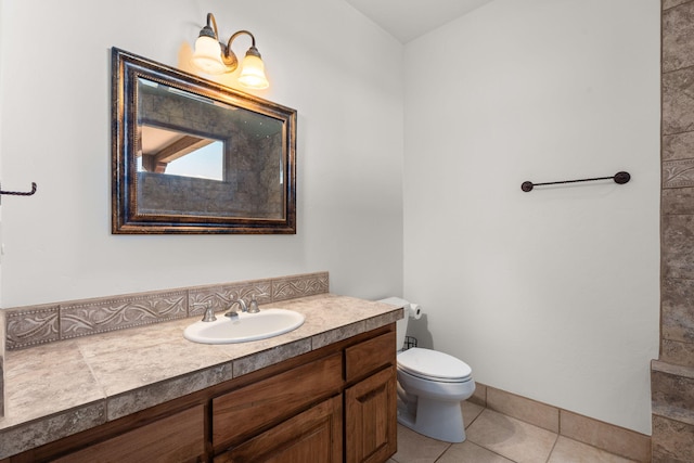 bathroom with toilet, vanity, and tile patterned floors