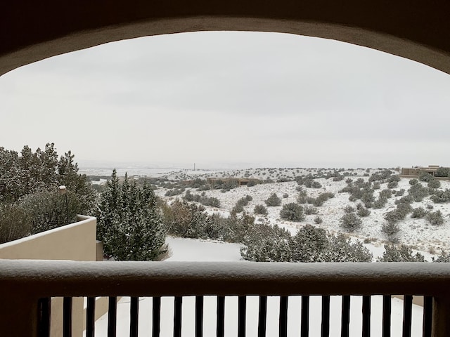 view of snow covered back of property