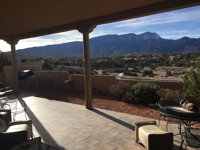 view of patio / terrace with grilling area, fence, and a mountain view