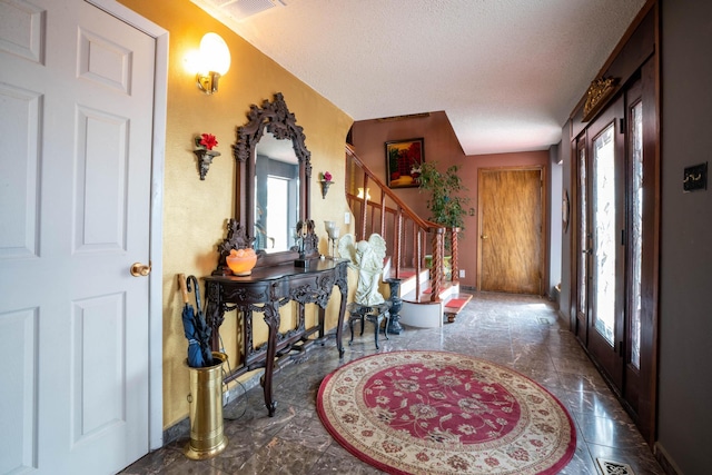 entryway featuring stairway and a textured ceiling