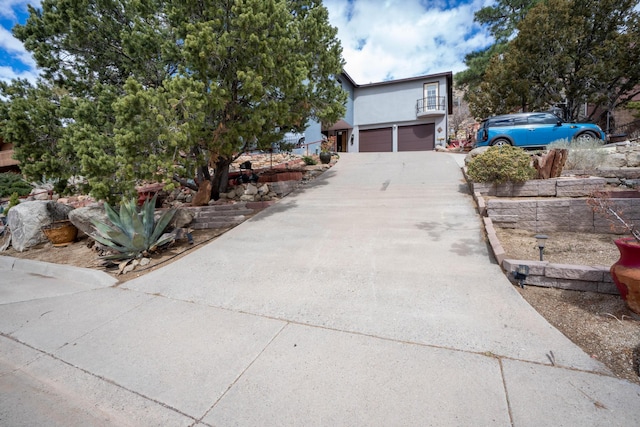 view of front of house featuring stucco siding, driveway, and a garage