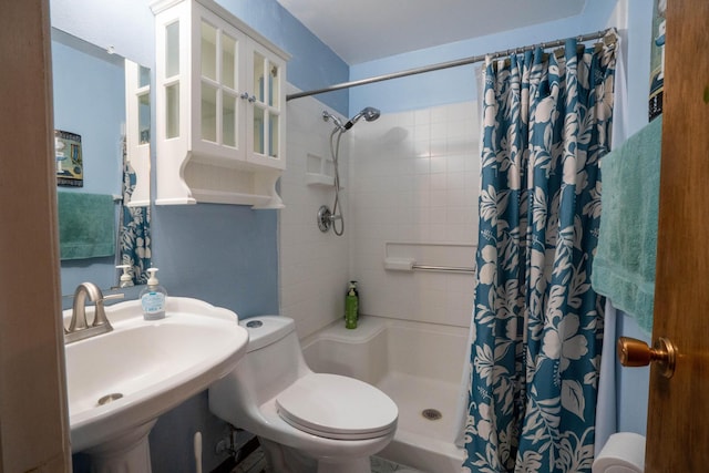 full bathroom with curtained shower, toilet, and a sink