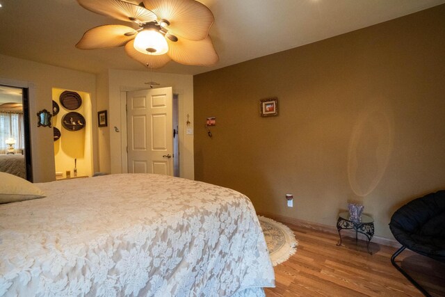 bedroom featuring baseboards, light wood-style floors, and a ceiling fan