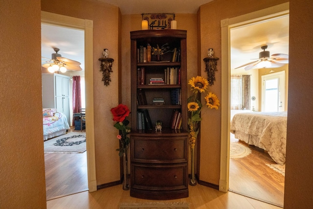 corridor featuring baseboards and wood finished floors