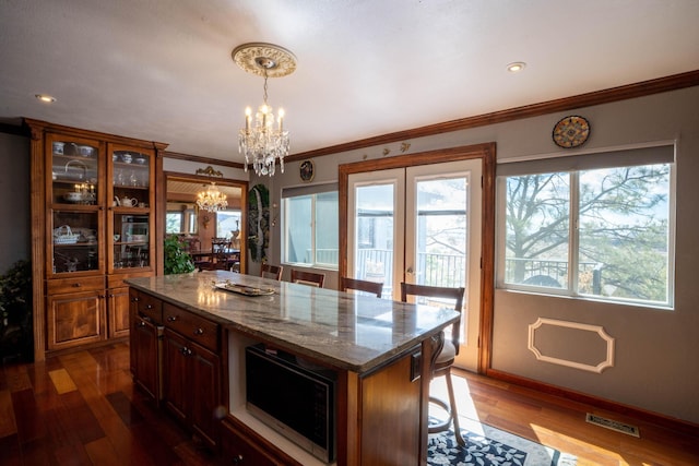 kitchen with visible vents, a center island, french doors, a chandelier, and dark wood-style flooring