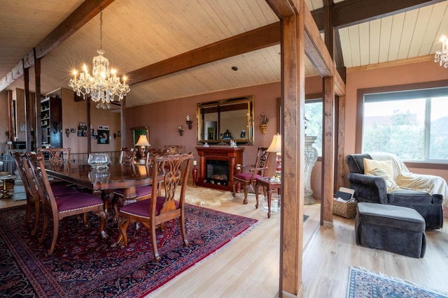 dining room with a chandelier, beam ceiling, a wealth of natural light, and wood finished floors