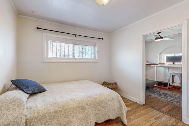 bedroom featuring ornamental molding, baseboards, and wood finished floors