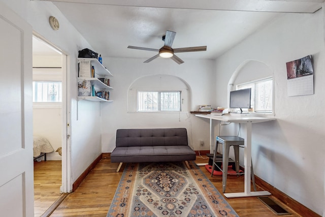 living area with light wood-type flooring, baseboards, visible vents, and a ceiling fan