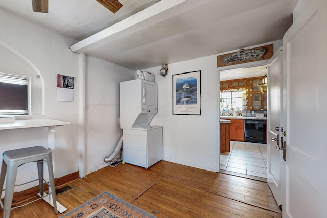 interior space with light wood finished floors, stacked washer / drying machine, and baseboards