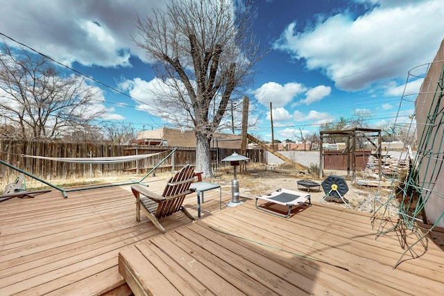 wooden deck with a fire pit and a fenced backyard