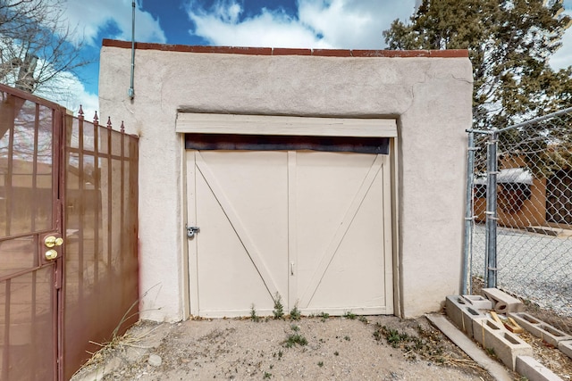 view of outbuilding featuring a gate and fence