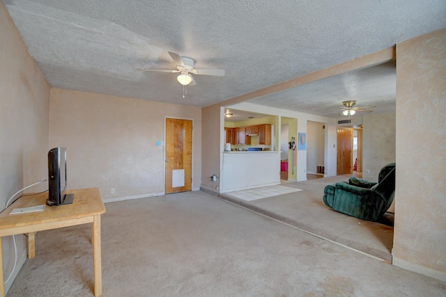 unfurnished living room with baseboards, light carpet, a textured ceiling, and ceiling fan