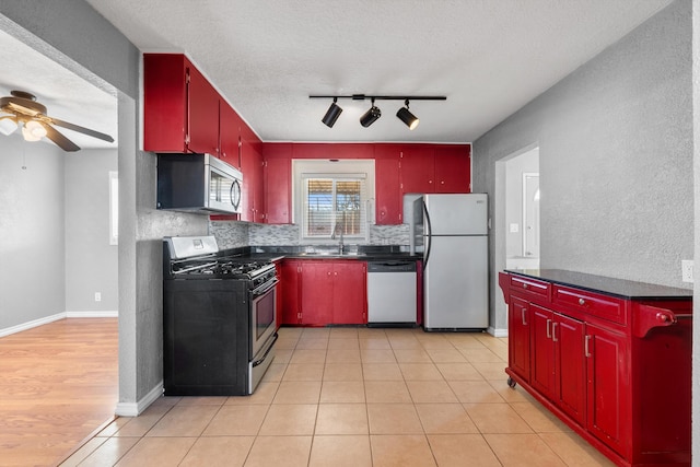 kitchen featuring dark countertops, red cabinets, stainless steel appliances, and ceiling fan