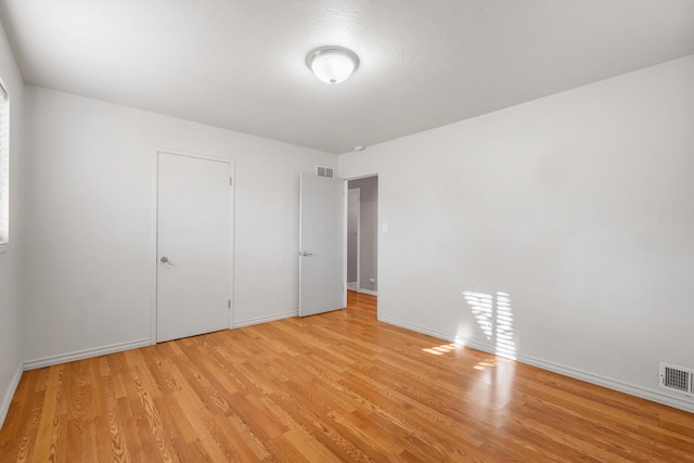 unfurnished bedroom with light wood-type flooring, visible vents, and baseboards