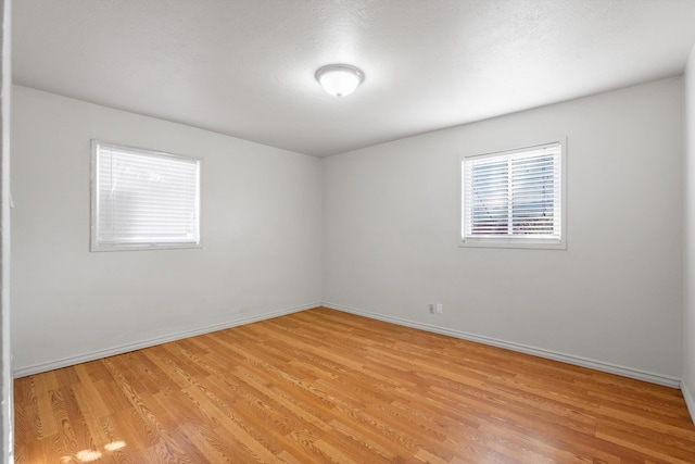 empty room featuring light wood-style flooring and baseboards