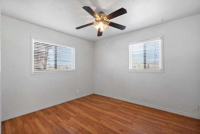 unfurnished room featuring baseboards, wood finished floors, and a ceiling fan