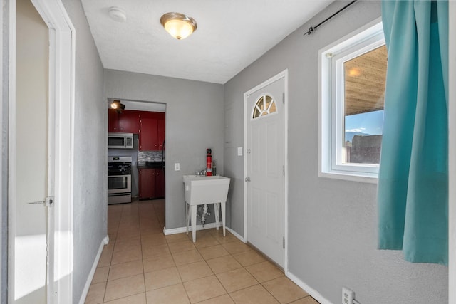 corridor with light tile patterned floors and baseboards