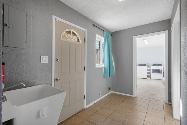 entryway with electric panel, a textured ceiling, a textured wall, and light tile patterned flooring