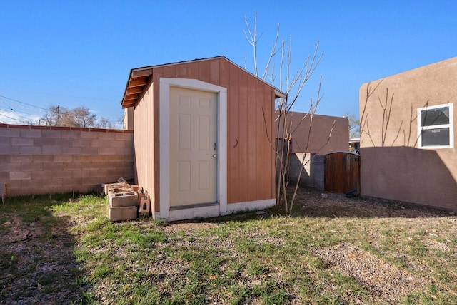 view of shed featuring a fenced backyard and a gate