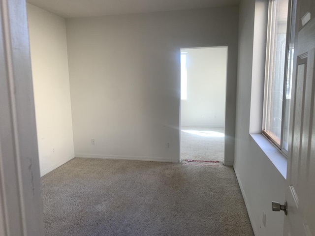 carpeted empty room featuring baseboards