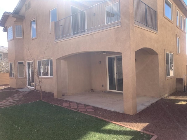 rear view of house with a patio and stucco siding