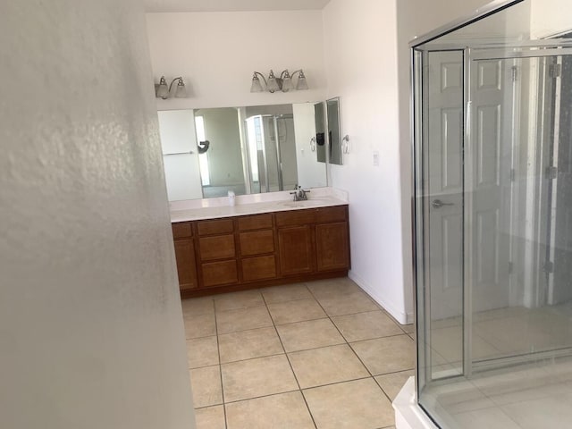 full bath featuring tile patterned floors, baseboards, a shower stall, and vanity