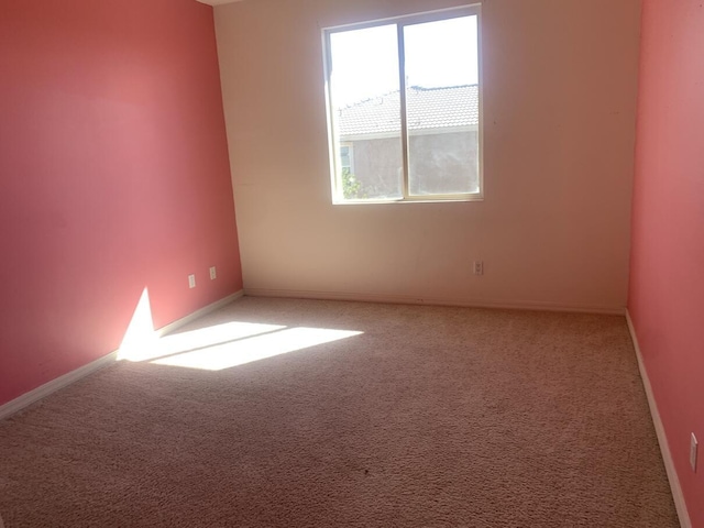 carpeted spare room with baseboards
