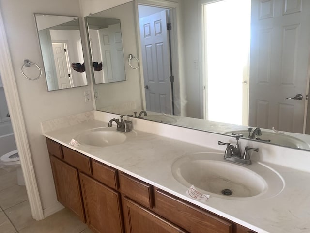 full bath with a sink, double vanity, and tile patterned floors