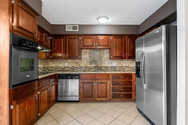 kitchen featuring decorative backsplash, visible vents, appliances with stainless steel finishes, and a sink