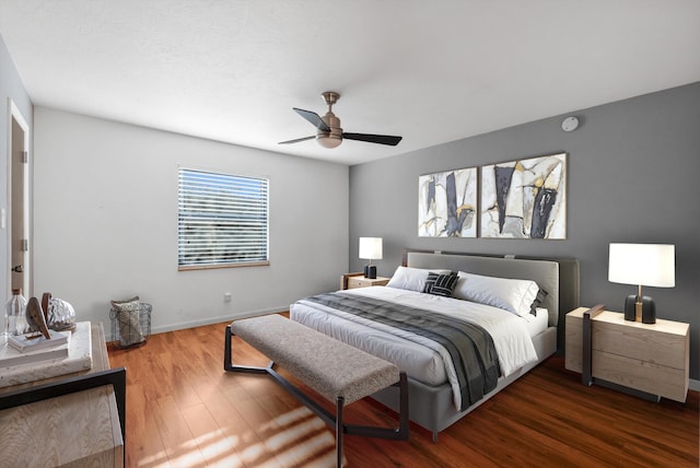 bedroom featuring ceiling fan, baseboards, and wood finished floors