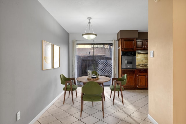 dining space with light tile patterned floors and baseboards