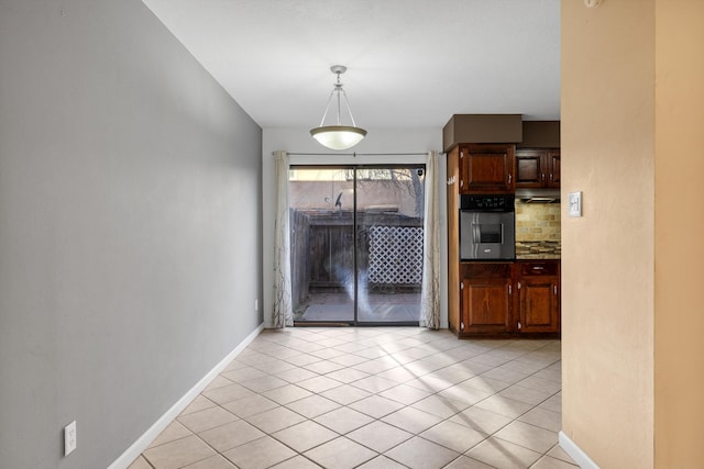 interior space with baseboards and light tile patterned flooring