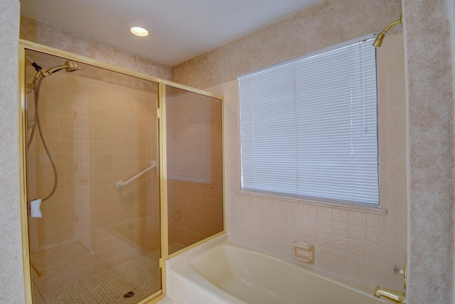 full bathroom featuring a bath and a shower stall