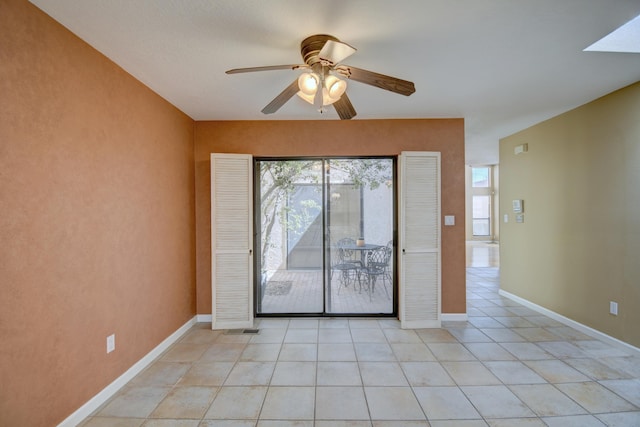 spare room featuring light tile patterned floors, baseboards, and a ceiling fan