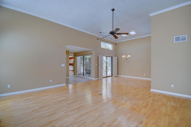 empty room featuring visible vents, crown molding, baseboards, ceiling fan with notable chandelier, and wood finished floors