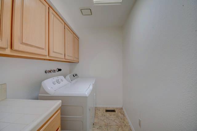 washroom with washing machine and dryer, cabinet space, visible vents, and baseboards