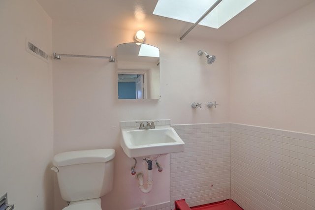 506 Onate Pl, Santa Fe, NM 87501 - half bathroom featuring visible vents, toilet, a skylight, tile walls, and a sink
