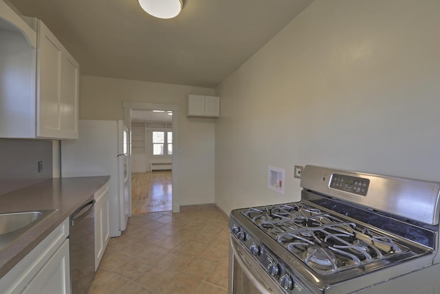 506 Onate Pl, Santa Fe, NM 87501 - kitchen featuring white cabinetry, dark countertops, light tile patterned flooring, and appliances with stainless steel finishes