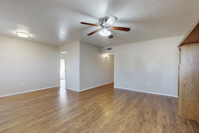 spare room featuring visible vents, baseboards, wood finished floors, and a ceiling fan