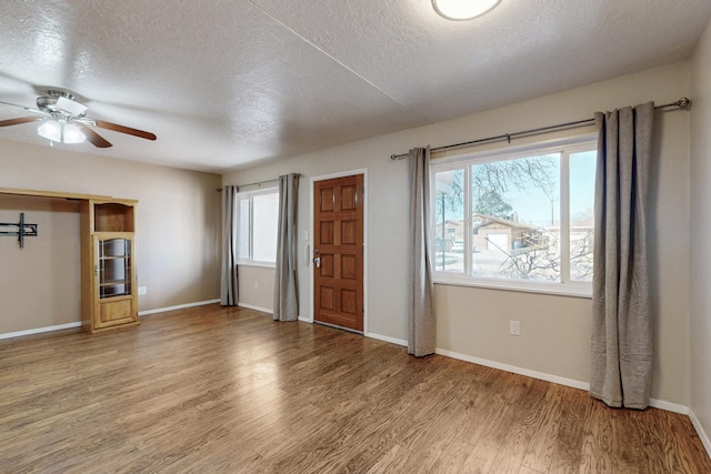 unfurnished bedroom featuring multiple windows, wood finished floors, and baseboards