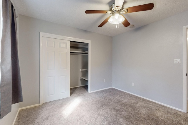 unfurnished bedroom with a closet, carpet floors, a textured ceiling, and baseboards