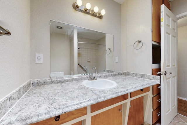 bathroom with vanity and a tile shower