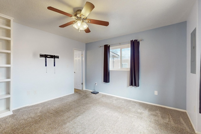 unfurnished room featuring built in shelves, a ceiling fan, baseboards, carpet floors, and a textured ceiling