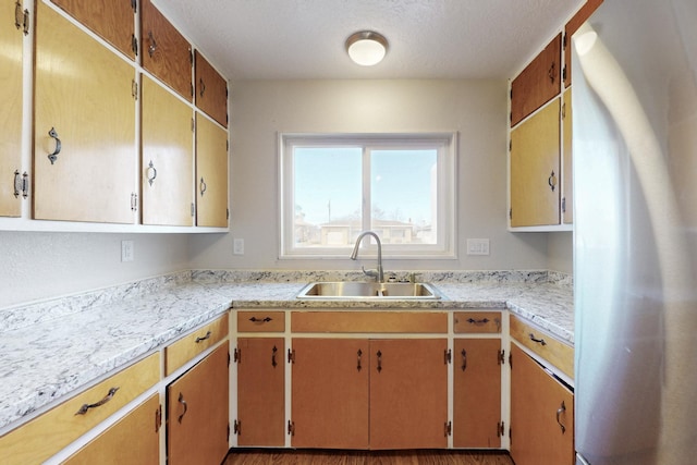 kitchen featuring a sink, light countertops, and freestanding refrigerator