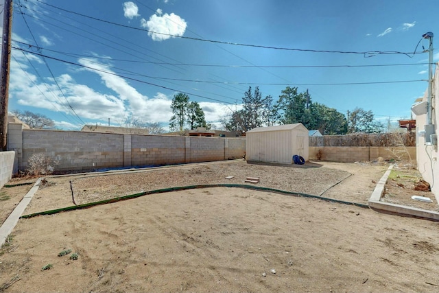 view of yard featuring an outdoor structure, a fenced backyard, and a shed